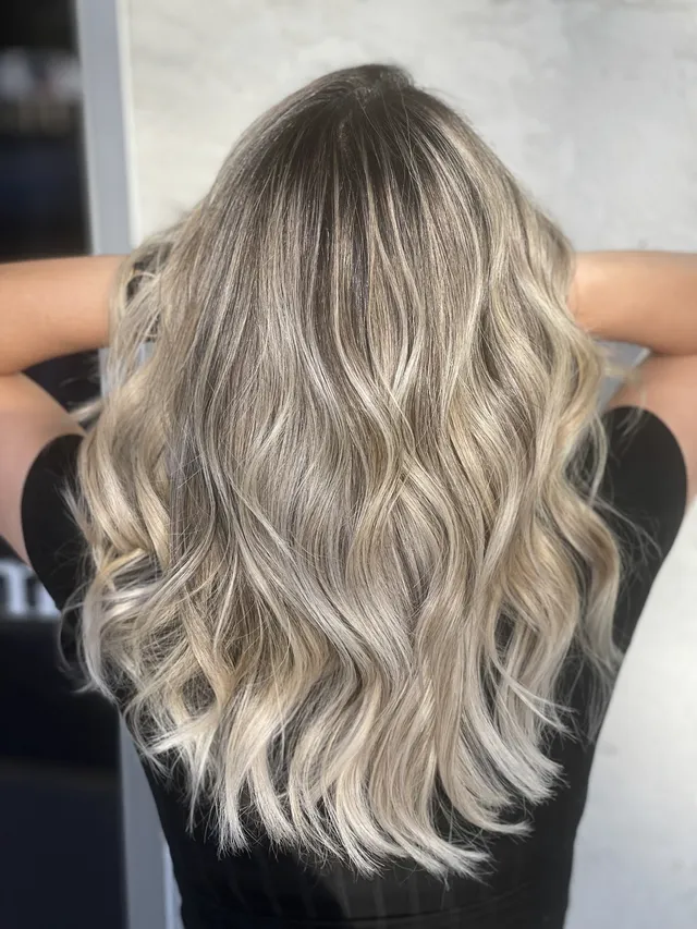 Ash blonde waves with lived-in dark root